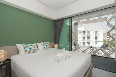 a bedroom with a large bed and a large window at Yanud Residence in Phuket Town