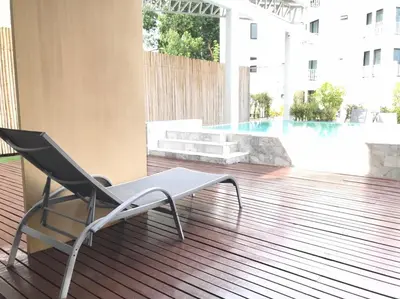 a chair sitting on a deck next to a pool at Yanud Residence in Phuket Town