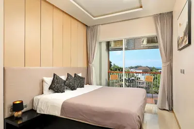 a bedroom with a bed and a balcony at Palmetto by Holy Cow, 2-BR, Sea View in Karon Beach