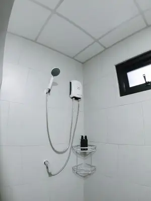 a white bathroom with a shower in a room at Nai Yang Residence in Nai Yang Beach