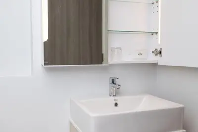 a bathroom with a white sink and a mirror at 1bdr Pool Access Apartment Bangtao #5103 in Bang Tao Beach