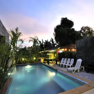 a swimming pool with chairs and a house at Serene Villa Phuket in Chalong