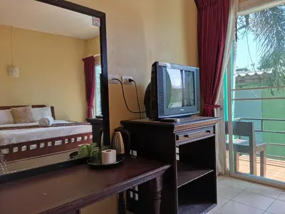 a room with a television on a dresser with a bed at Serene Villa Phuket in Chalong
