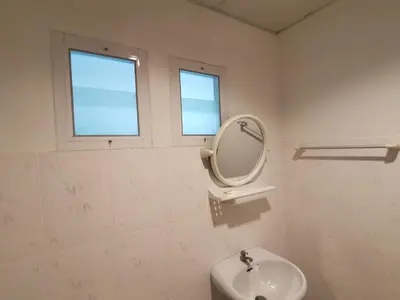 a white bathroom with a mirror and a sink at Serene Villa Phuket in Chalong