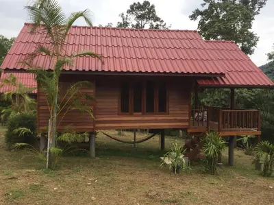 a small wooden house with a red roof at Sabai House Bungalow in Ko Yao Noi