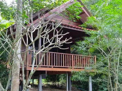 a tree house with a deck in the woods at Sabai House Bungalow in Ko Yao Noi