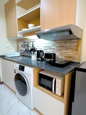 a kitchen with a stove and a washing machine at Pak Dee At Naithon in Nai Thon Beach