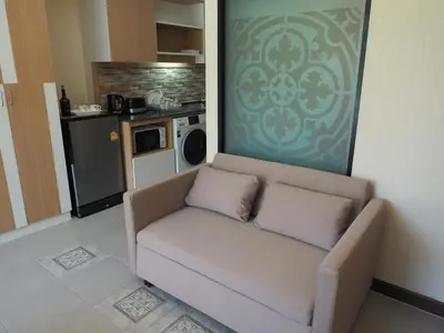a living room with a couch and a kitchen at Pak Dee At Naithon in Nai Thon Beach