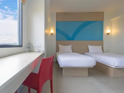 a room with two beds and a red chair at HOP INN Phuket Old Town in Phuket Town