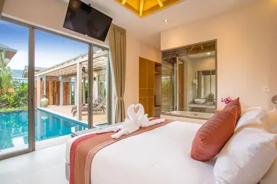 a bedroom with a large bed and a swimming pool at Boutique 2BR Pool Villa Dalaa 1, Gated Residence, Kamala Beach in Kamala Beach