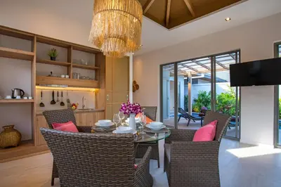 a dining room with a table and chairs and a chandelier at Boutique Resort 2BR Pool Villa Dalaa 2, Kamala Beach in Kamala Beach