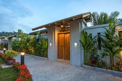 a house with a wooden door and some plants at Boutique Resort 2BR Pool Villa Dalaa 2, Kamala Beach in Kamala Beach