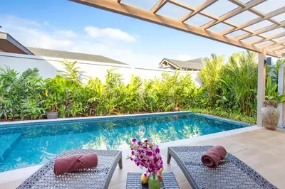 a swimming pool with two chairs next to a pool at Boutique Resort 2BR Pool Villa Dalaa 2, Kamala Beach in Kamala Beach