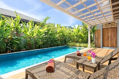 a swimming pool with a table and chairs next to a villa at Private Resort Boutique Pool Villa Dalaa 5 , near Kamala Beach in Kamala Beach