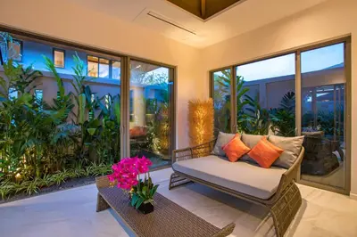 a porch with a chair and a table and some plants at Kamala Pool Villa, Dalaa 6 in Kamala Beach