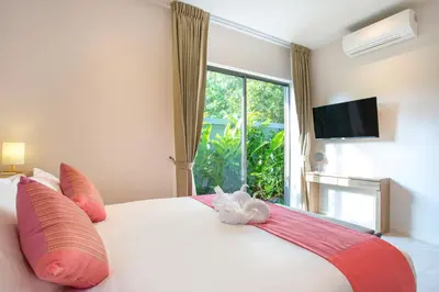 a bedroom with a large white bed with a window at Kamala Pool Villa, Dalaa 6 in Kamala Beach