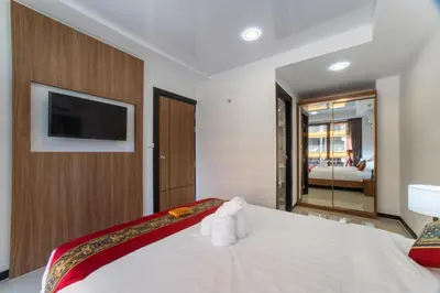 a bedroom with a white bed with towels on it at NARA Condo 1BR Pool View NBC Nai Harn in Nai Harn Beach