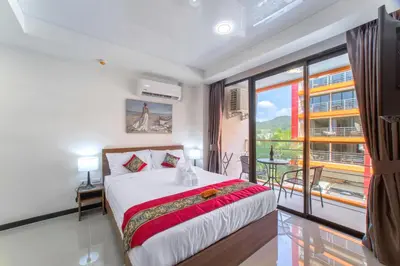 a bedroom with a bed and a large window at NARA Condo 1BR Pool View NBC Nai Harn in Nai Harn Beach