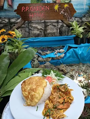 a plate of food with rice and meat on a table at P P Garden Home Bungalow in Phi Phi Don