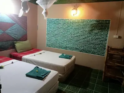 a room with two beds and a brick wall at P P Garden Home Bungalow in Phi Phi Don
