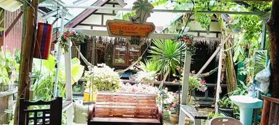 a garden room with a wooden bench and plants at P P Garden Home Bungalow in Phi Phi Don