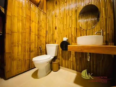 a wooden bathroom with a toilet and a sink at KLONGBON GARDEN HOME Koh Yao Yai in Ko Yao Yai