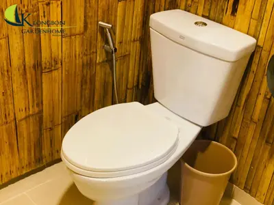 a bathroom with a white toilet and a trash can at KLONGBON GARDEN HOME Koh Yao Yai in Ko Yao Yai