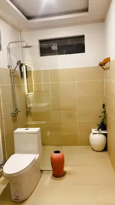 a bathroom with a toilet and a shower and a vase at KLONGBON GARDEN HOME Koh Yao Yai in Ko Yao Yai