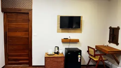 a room with a refrigerator and a television on the wall at KLONGBON GARDEN HOME Koh Yao Yai in Ko Yao Yai