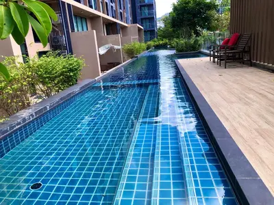 a swimming pool with blue tiles on the side of a building at Aristo Resort Surin Beach K02 in Surin Beach