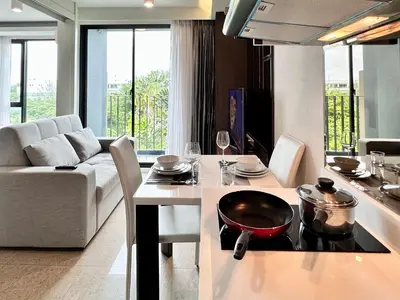 a kitchen and living room with a table and a stove at Aristo Resort Surin Beach K02 in Surin Beach