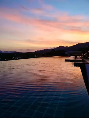 a view of a swimming pool at sunset at Aristo Resort Surin Beach K02 in Surin Beach