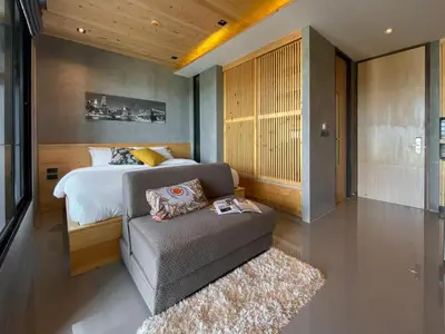 a bedroom with a bed and a couch in it at ReLife Windy Naiharn by Beringela in Nai Harn Beach