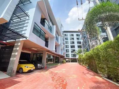 a street in front of a building with a yellow car at ReLife Windy Naiharn by Beringela in Nai Harn Beach
