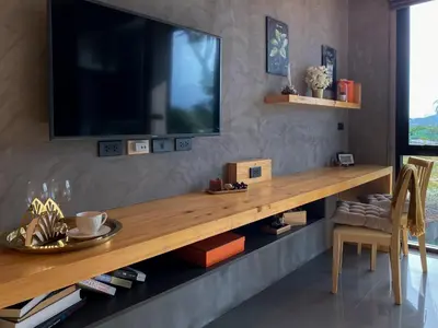 a living room with a large television on a wall at ReLife Windy Naiharn by Beringela in Nai Harn Beach