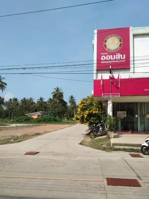 an empty street in front of a pink building at Baan Kebsap บ้านเก็บทรัพย์ in Ko Yao Noi