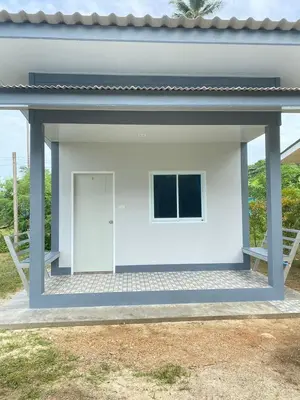 a large white building with a door on a patio at Baan Kebsap บ้านเก็บทรัพย์ in Ko Yao Noi