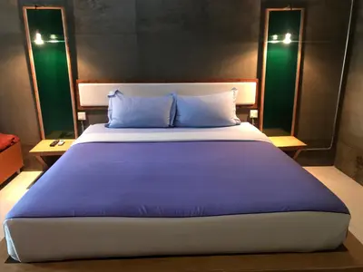 a large bed with blue pillows in a room at Cafe'@luv22 in Phuket Town