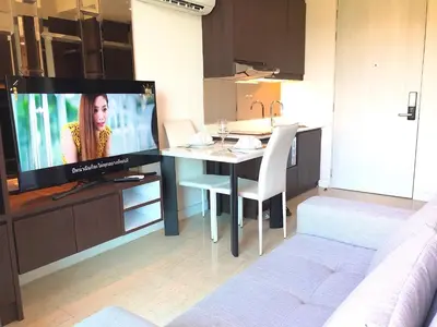 a living room with a table and a tv in a kitchen at Aristo Resort Surin Beach J16 in Phuket Town