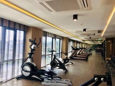 a gym with rows of treadmills and exercise bikes at Aristo Resort Surin Beach J16 in Phuket Town