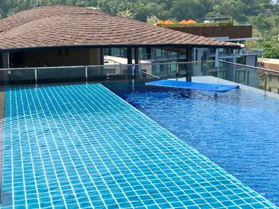 a large swimming pool with a blue swimming poolvisor at Aristo Resort Surin Beach J16 in Phuket Town