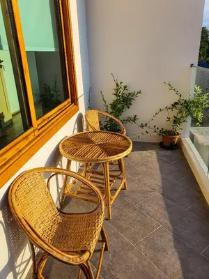 two wicker chairs and a table on a patio at Wayla Villa@Maikhaobeach in Mai Khao Beach