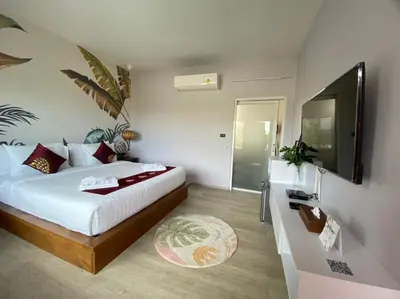 a bedroom with a bed and a flat screen tv at Wayla Villa@Maikhaobeach in Mai Khao Beach