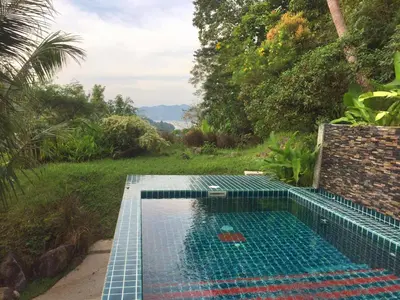 a swimming pool in the middle of a garden at Patong Garden House - Luxury Villa in Patong Hills in Patong Beach