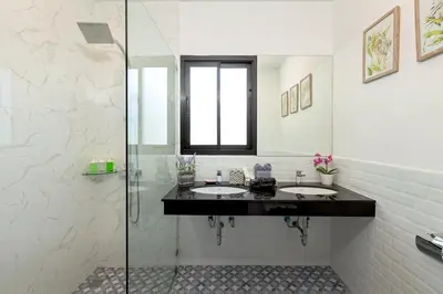 a bathroom with two sinks and a glass shower at Patong Garden House - Luxury Villa in Patong Hills in Patong Beach