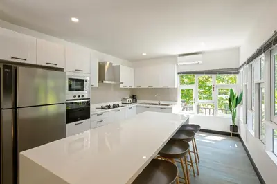 a kitchen with white cabinets and a large white counter top at Patong Garden House - Luxury Villa in Patong Hills in Patong Beach