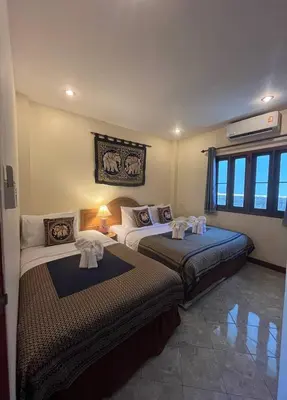 a bedroom with two beds with towels on them at Ginis Beach Resort in Kamala Beach