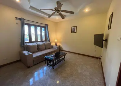 a living room with a couch and a ceiling fan at Ginis Beach Resort in Kamala Beach