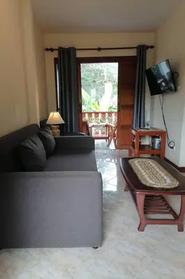 a living room with a couch and a table at Ginis Beach Resort in Kamala Beach