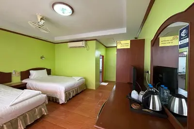 a hotel room with two beds and a television at Me Mee Place & Tour Krabi in Ao Nang Beach